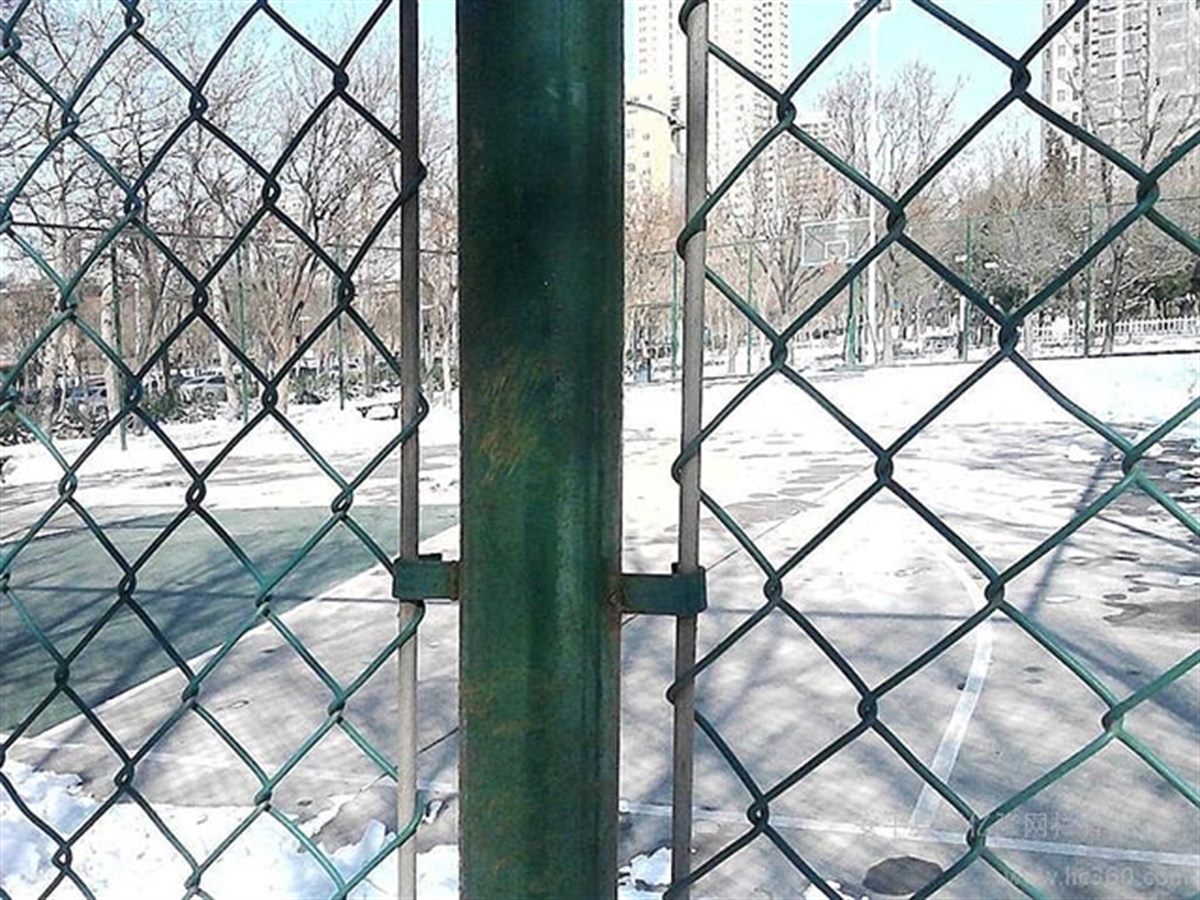 Chain-Link Fence — Woven chain-link mesh fence panels standing in a row along a boundary