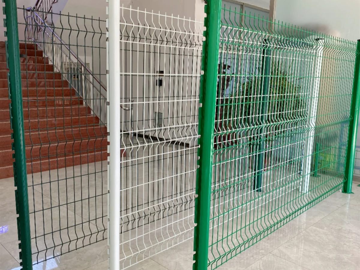 Peach-post mesh fence panels standing in a row along a perimeter run (thumbnail 2)